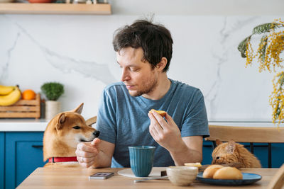 Young man looking up while holding food