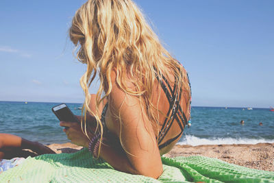 Rear view of woman standing on beach