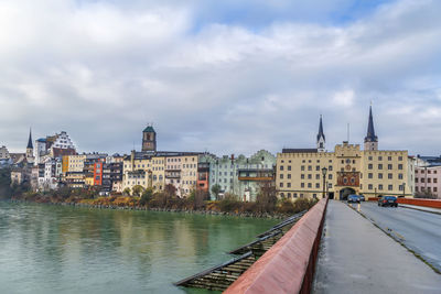 River amidst buildings in city against sky