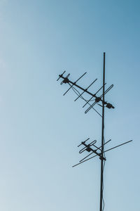 Low angle view of weather vane against clear sky