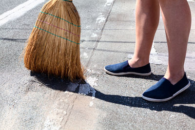 Exterior cleaning with corn broom . courtyard floor sweeping . feet and corn broom