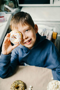 Funny boy with donut. child is having fun with doughnut. tasty food for kids.