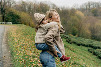 Little girl riding on her mother's back