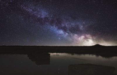 Scenic view of lake against sky at night