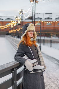 Portrait of young woman standing in city