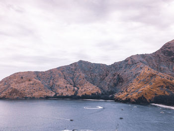 Scenic view of sea and mountains against sky