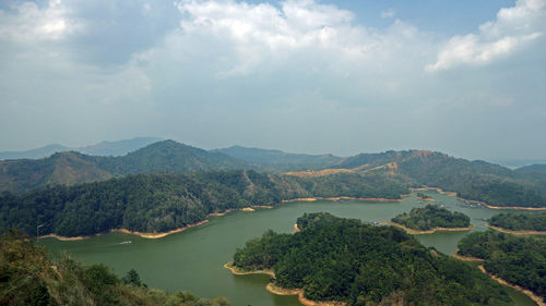 Scenic view of river and mountains against sky