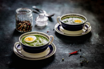 High angle view of spinach soup with egg with spice served on table