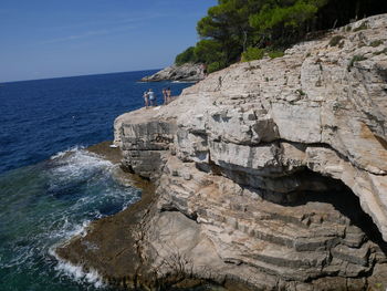 Rock formation on beach against sky