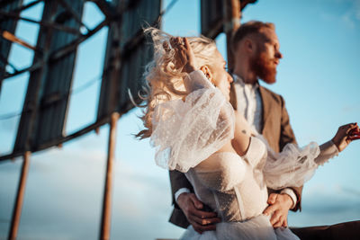 Low angle view of couple kissing outdoors