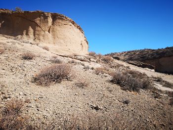 Rock formations in desert against clear blue sky