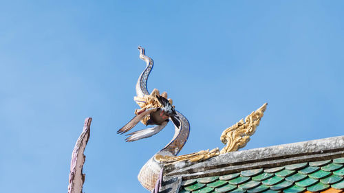 Low angle view of a statue against blue sky