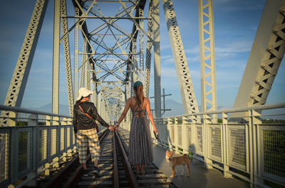 Woman standing on bridge against sky