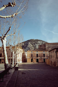 Empty road by buildings against sky