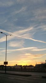 Street lights against sky during sunset