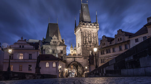 Historic buildings against cloudy sky at night