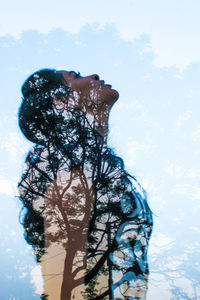 Digital composite image of silhouette man and tree against sky
