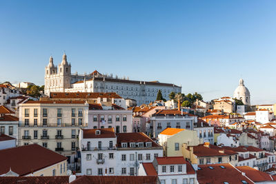 Buildings in city against clear sky