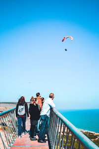 People on sea against clear sky