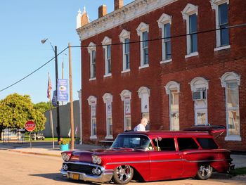 Vintage car on street against buildings in city