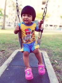 Portrait of cute girl on swing in playground