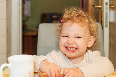 Portrait of happy boy with coffee at home