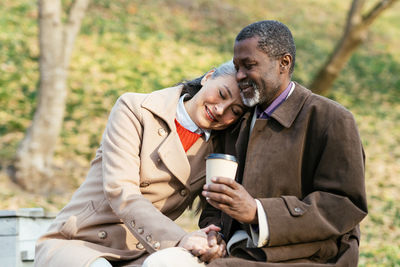 Young man using mobile phone while sitting on field