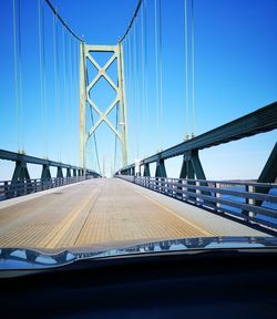 Bridge against clear sky seen through car windshield