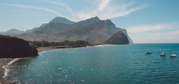 Scenic view of sea and mountains against sky