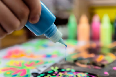 Close-up of hand holding multi colored pencils