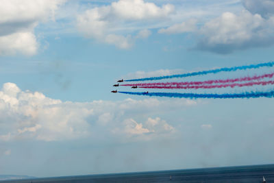 Low angle view of airshow against sky