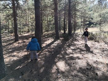 Rear view of people walking in forest