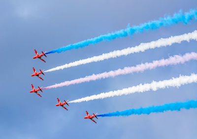 Low angle view of fighter plane performing smoking stunt against clear sky