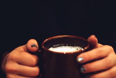 Cropped image of hand holding object over white background