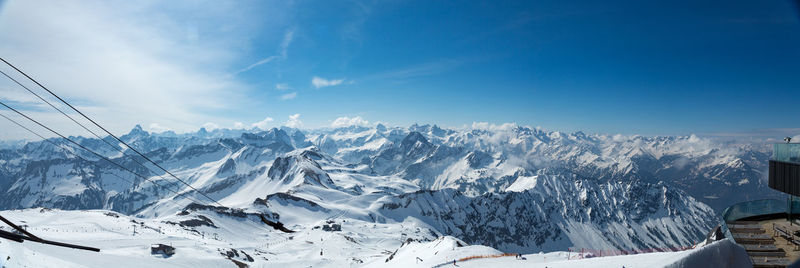 Scenic view of snowcapped mountains against blue sky