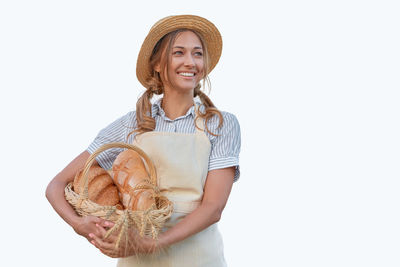 Portrait of a smiling young woman wearing hat against white background