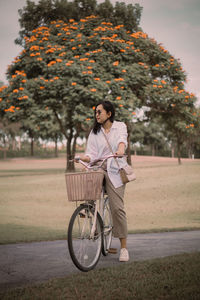 Side view of young woman riding bicycle on road