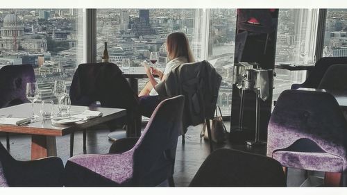 Rear view of woman sitting on table