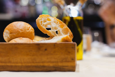 Appitizer slice of sourdough and bread buns on dinner table.