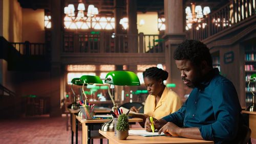 Side view of young woman using mobile phone while sitting in cafe
