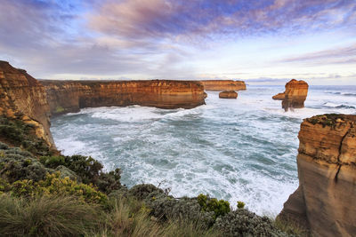 Scenic view of rocks in sea against sky