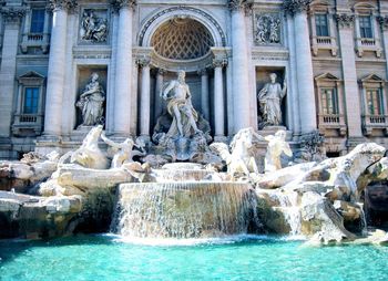 Statue of fountain in front of historical building