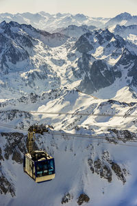 Cable car in the pyrenees mountains with snowy high-altitude mountain peaks in the winter