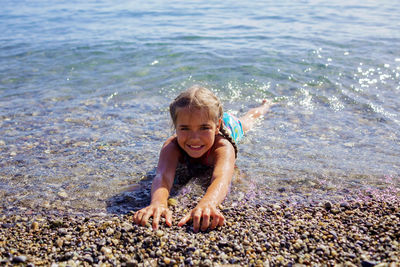 Girl has fun on pebble beach on geneva lake, fun, happiness, summer vacations and travel