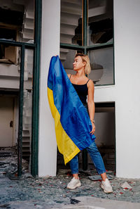 Portrait of woman standing against wall