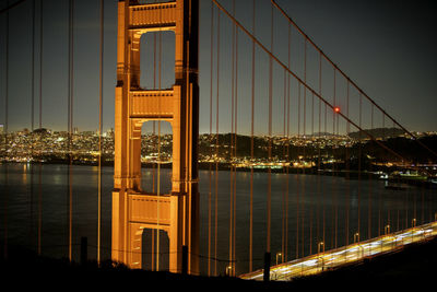 View of suspension bridge in city at night