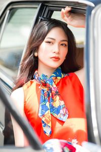 Portrait of young woman sitting in car