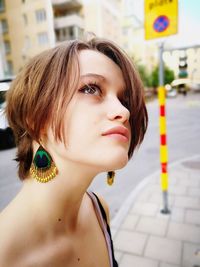 Portrait of young woman looking away in city