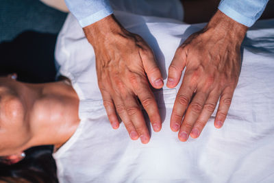 Woman in reiki spiritual healing session. reiki therapist holding hands above heart chakra 