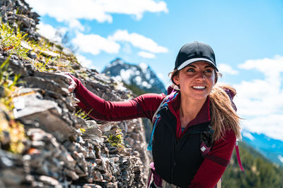 Hiker balancing herself along mountain scramble in kananaskis country